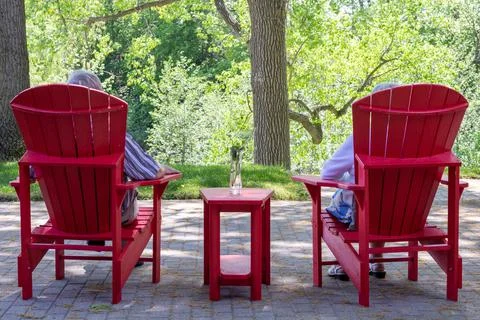Older Couple Red Muskoka Chairs Stock Photos