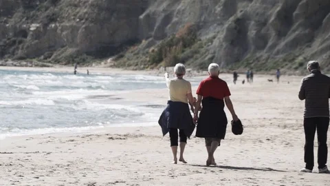 Older couple sight-seeing on beach Stock Footage 89693295