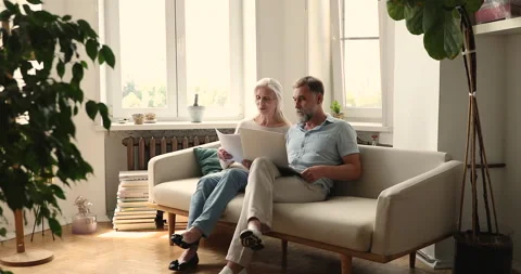 Older couple use laptop, learn documents, sorting out papers Video stock 169824585