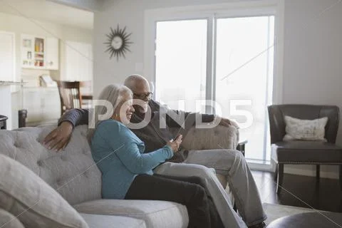 Older Couple Using Digital Tablet On Sofa