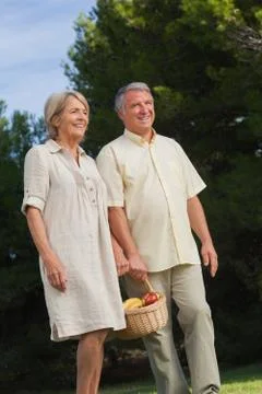 Older couple walking with basket of fruit Stock Photos