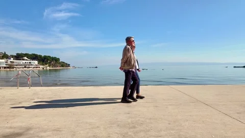 Older Couple Walking Past Bench at Split Bačvice Beach in Winter Stock Footage 331449592