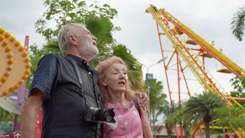 Older couples are visiting amusement parks, they are fun like children Stock Footage 134479069