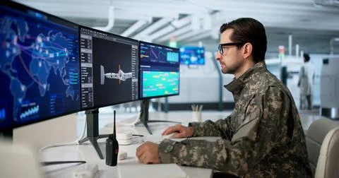 Older Engineer Uses Computer Software To Monitor Drone Factory Production. Stock Photos