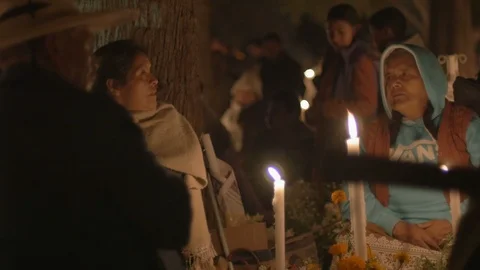An older family sitting at a graveyard during day of the dead in Mexico Video stock 88962953