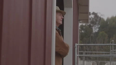 Older Farmer Stands At Edge Looking Out Of Barn Stock Footage 270336128