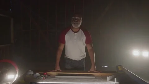 Older Guy Stands From Leaning On Work Table At Night Stock Footage 270390672