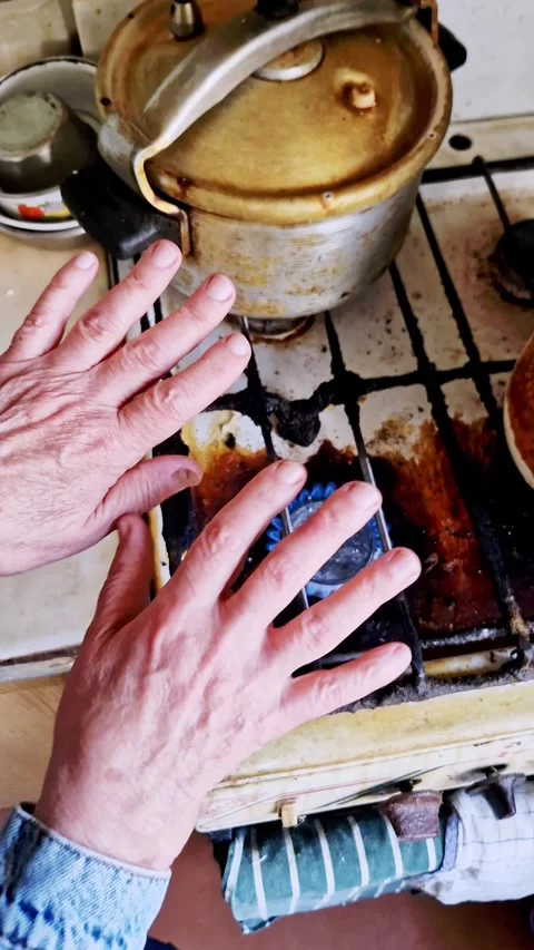 Older Hands Warming Over a Blue Gas Flame Stock Footage 321971707