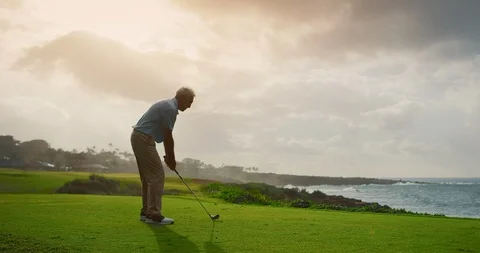 Older Handsome golf takes a swing on beautiful golf course Stock Footage 102409430