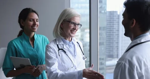 Older head physician congratulate intern... | Stock Video | Pond5