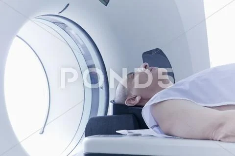 Older Hispanic Man Laying In Mri Scanner