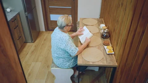Older lady systematically reviews and arranges letters. An aged woman Stock Footage 332278434