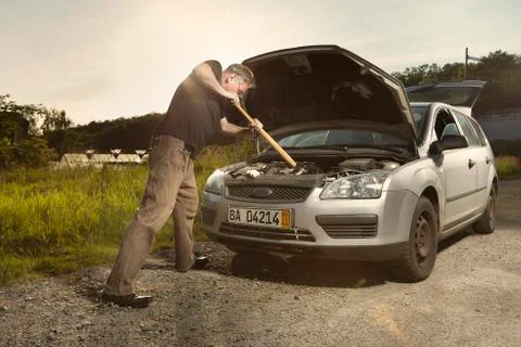 Older man alone on route checking unfunctional engine in late summer light Stock Photos