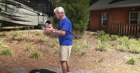 Older man catches and throws football to off-camera person (slow motion) Stock Footage 69125830