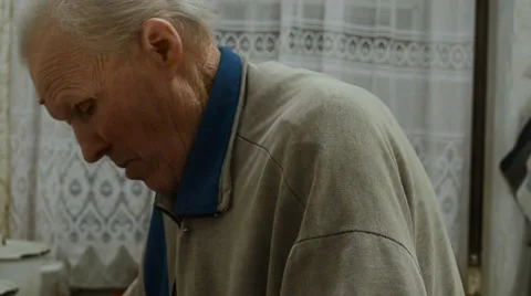 Older Man Cuts a Huge Chunk of Meat Into Many Small With a Knife Standing in Stock Footage 61520210