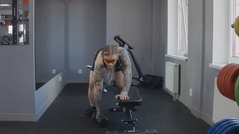 An older man does an exercise on the broad muscles of the back Stock Footage 115429296