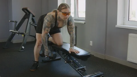 An older man does an exercise on the broad muscles of the back Stock Footage 115429301