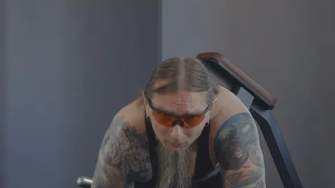 An older man does an exercise on the broad muscles of the back Stock Footage 115429589