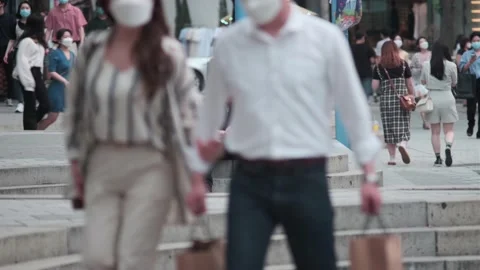 Older man examining smartphone as young Koreans walking around during Covid-19 Stock Footage 137363668