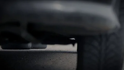 An older man independently changes the wheel in his car in the middle of the Stock Footage 128773829