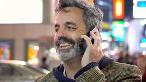 Older man laughing while talking on mobile smart cell phone Stock Photos