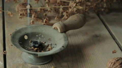 An older man lights incense burner with a match on a wooden table. 動画素材 130470366