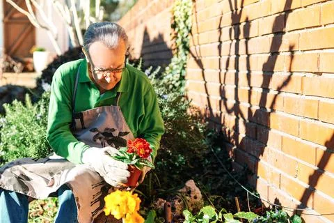 Older man relaxing, while tending to his garden Stock Photos