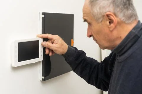 Older man repairing intercom system Foto stock