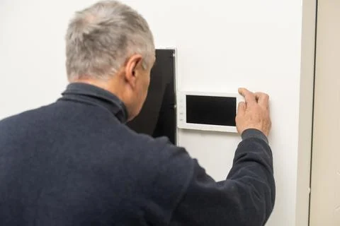 Older man repairing intercom system Stock Photos