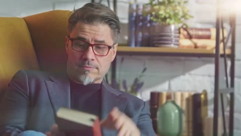 Older man resting at home reading book Stock Footage 142275813