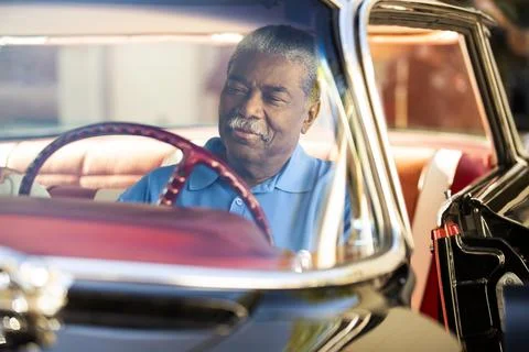 Older man sitting in drivers seat of 1960 Oldsmobile Super 88 Holiday Sport Stock Photos