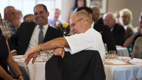 Older man sitting at a table and listening to a speech during a wedding. Stock Footage 102189260