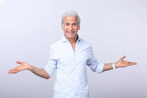 Older Man Smiling While Pointing Finger Upward In Studio Stock Photos