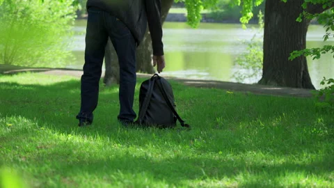 An older man strolled through the park and sat down on the green lawn Stock Footage 244240918