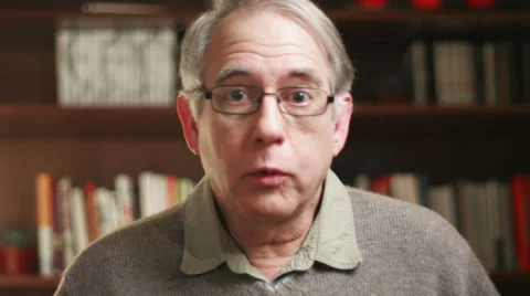 A older man talking over a video chat and taking glasses off. Close up shot Stock Footage 33841329
