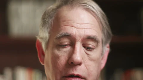 A older man talking over a video chat and putting his glasses on. Close up shot Stock Footage 33841445