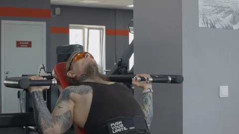 An older man is training on multi press machine. Stock Footage 115429828