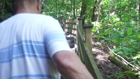 Older man trying to climb up a set of wooden stairs Stock Footage 111423796