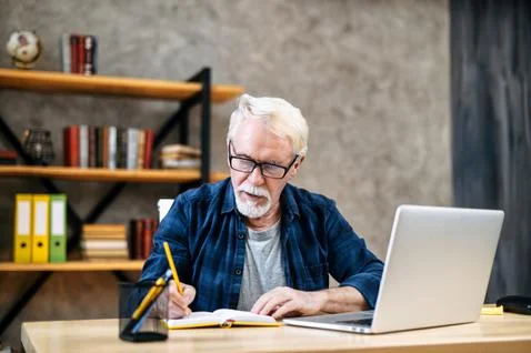 Older man using laptop for studying, working Foto stock