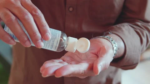 Older man using liquid hand sanitizer during quarantine. People using alcohol Stock Footage 135073220