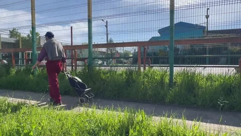 Older man walking through the city with a shopping cart. Stock Footage 319955591