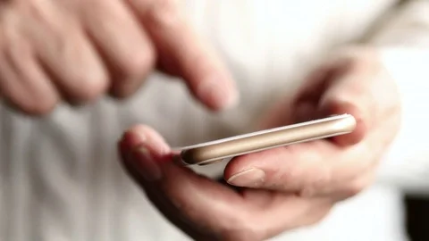 An Older Man In A White Sweater Text Messaging On Smartphone In A Bright Sunny D Stock Footage 73017898