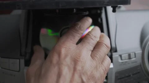 Older man with wrinkled hand changing CD disk in retro music boombox. Stock Footage 164767150