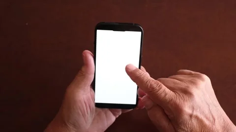 Older man's hands holding a black smartphone with a white screen, scrolling Stock Footage 344396457