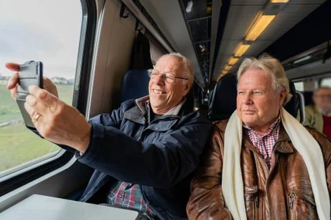 Older men making a selfie in train. Stock Photos