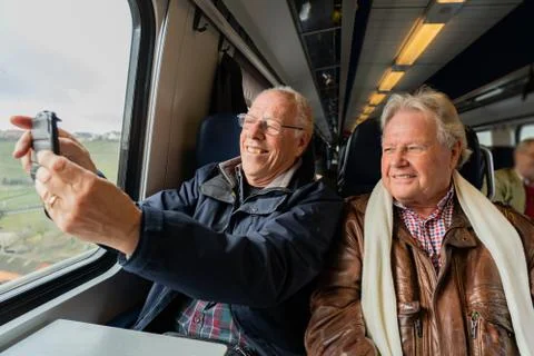 Older men making a selfie in train. Stock Photos