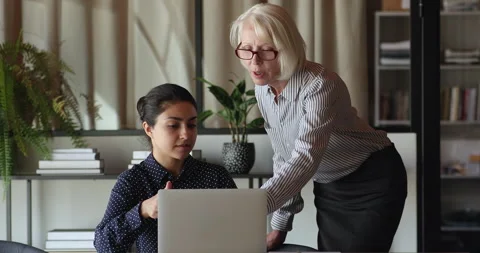 Older mentor help to Indian young employee with corporate app Stock Footage 158052870