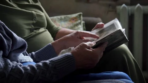 Older people spend a quiet time watching a photo album together Stock Footage 321389985