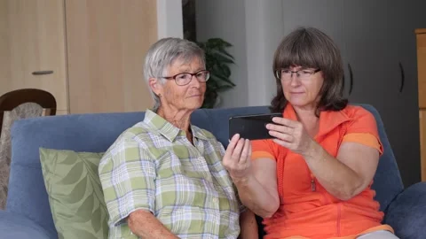 Older people of two generations look at smartphone screen and talk about Stock-Footage 133423489