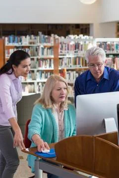 Older people using computer in library Stock Photos